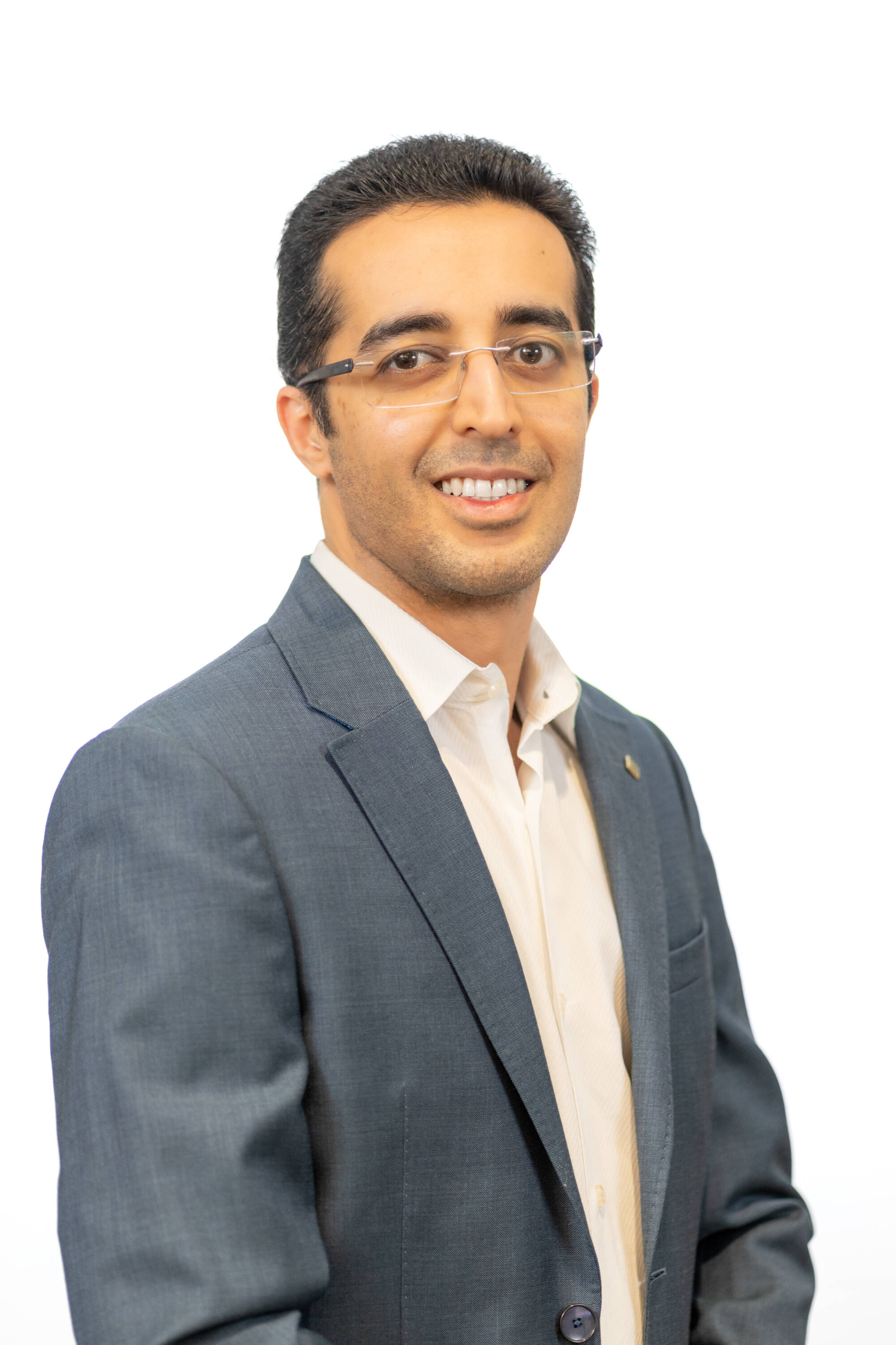 photo of faculty member, Vinay Bhatia, against a white background wearing a grey suit coat and light colored button down.